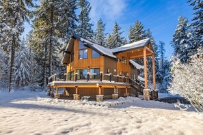 A wooden cabin with a balcony, surrounded by snow-covered trees. - Cle Elum Sunrise Lodge (Cle Elum)