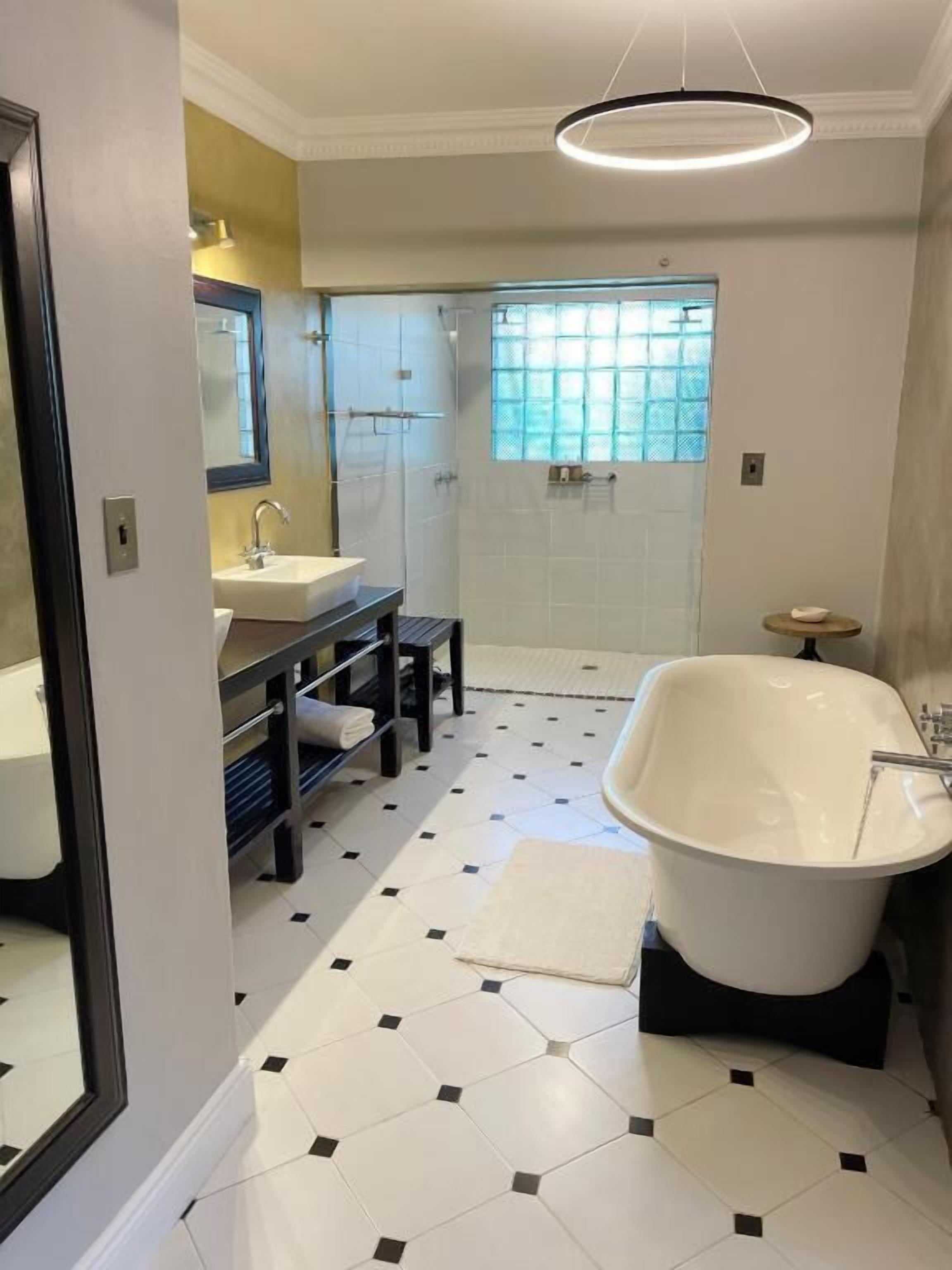 A bathroom with a white sink, a bathtub, and a shower area.