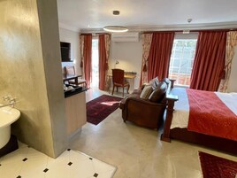 Una habitación de hotel con cama, sofá, escritorio y baño.