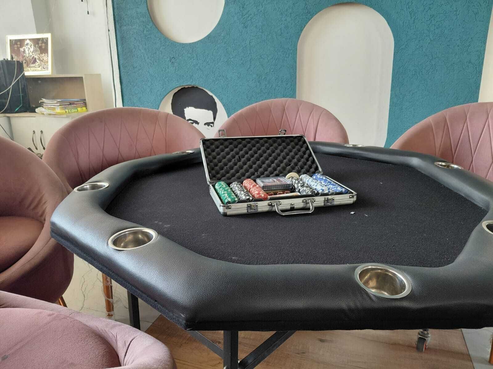 A poker table with chips and a case in the center, surrounded by chairs.
