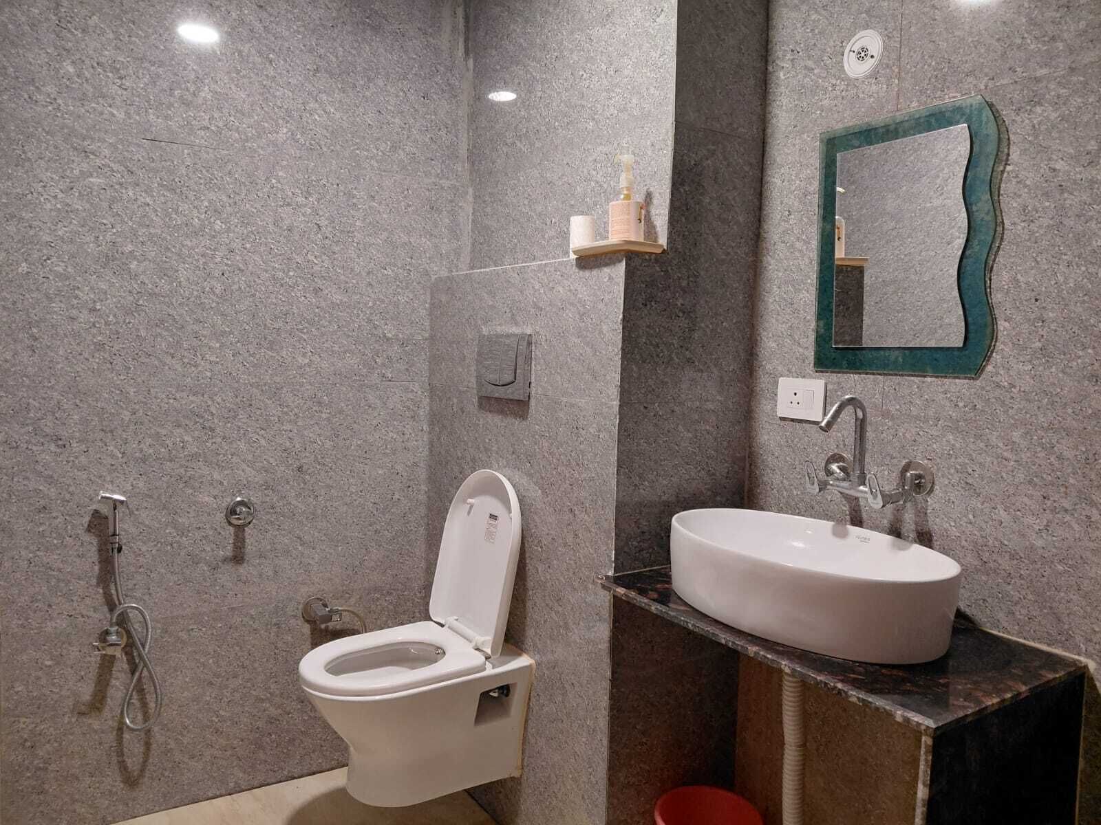 A bathroom with a toilet, sink, and shower.