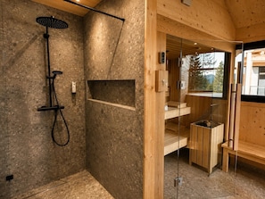 A modern bathroom with a shower, wooden shelves, and a glass door leading to a balcony. - Superior Chalet # 50 with Sauna & Hot Tub (Turrach)