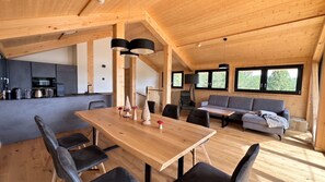 Een modern interieur van hout met een eethoek, keuken en zithoek.