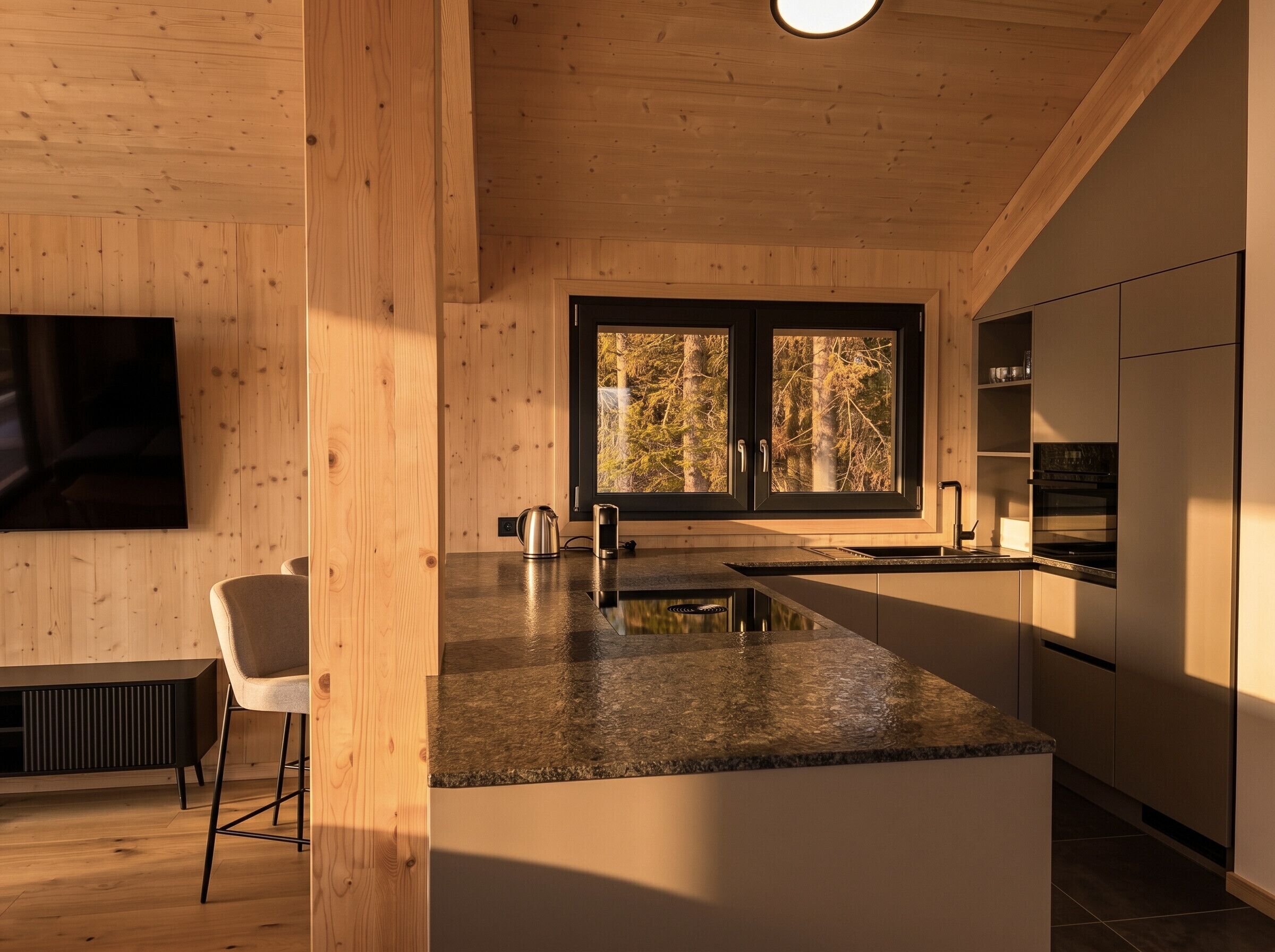 Une cuisine moderne avec un intérieur en bois, une grande fenêtre et un îlot central intégré.