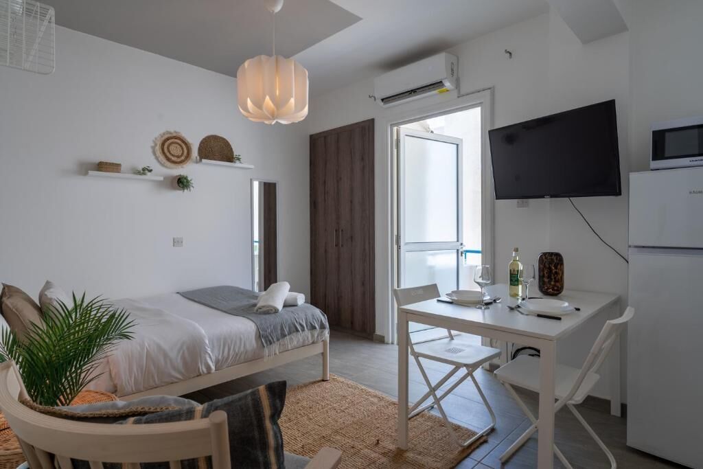 A modern bedroom with a bed, bedside table, and a TV.