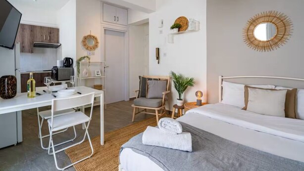 A modern hotel room with a bed, a desk, and a kitchenette. - Orchid Cozy Studio & Balcony in Larnaca (Larnaca)