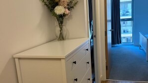 Ein weißer Kommode mit Schubladen und einer Blumenvase darauf.