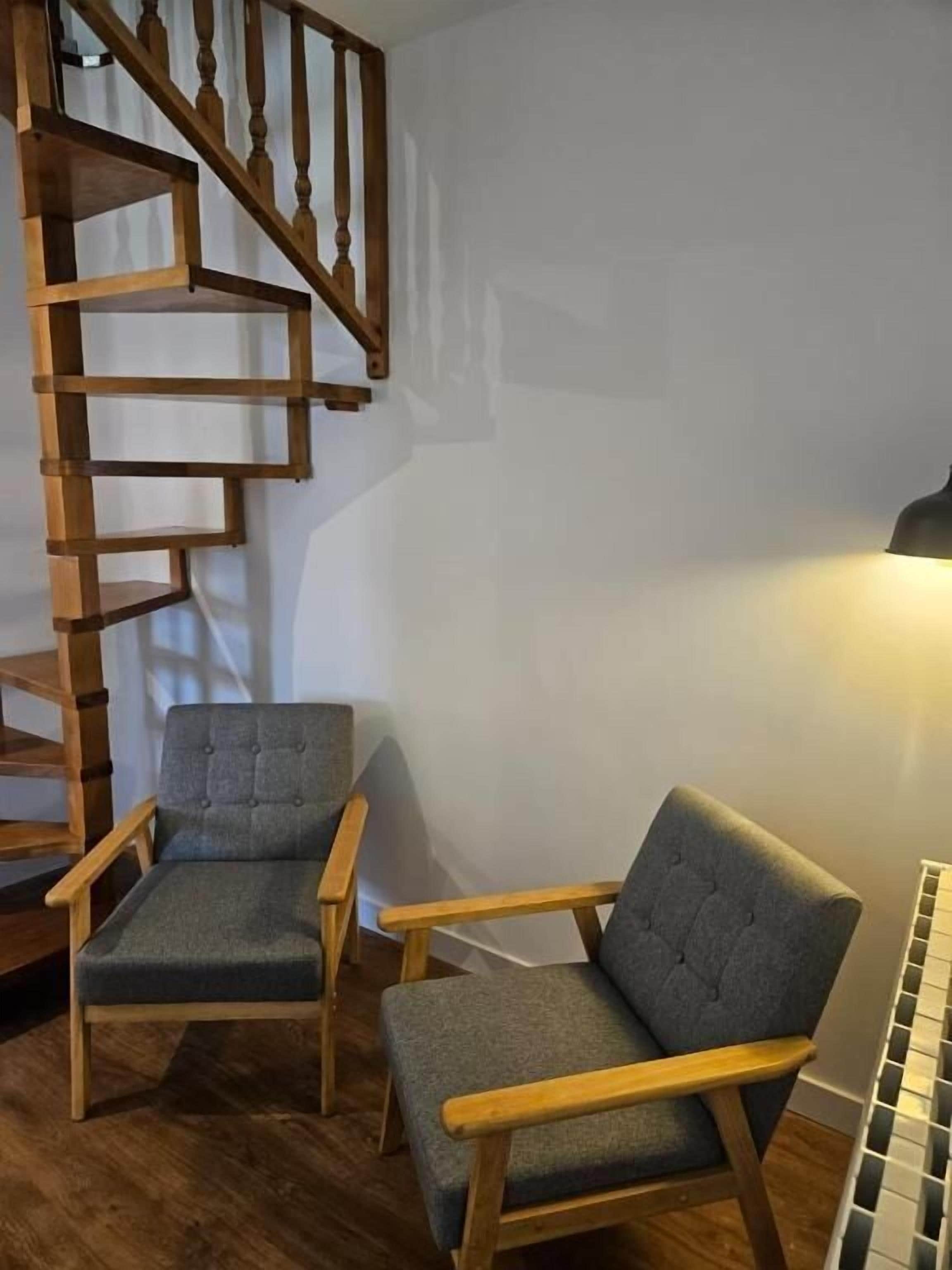 Un escalier avec des rampes en bois et un luminaire fixé au mur.