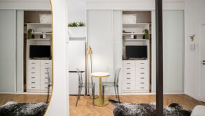 A modern interior with a mirrored wall, a round table, clear chairs, and a white cabinet with drawers. - Bondi Beachside Escape - Surf & Vibe (Bondi Beach)