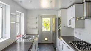 Una cocina moderna con armarios blancos, electrodomésticos de acero inoxidable y una isla central.