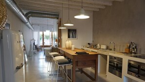 Uma cozinha moderna com mesa de madeira, banquetas e eletrodomésticos embutidos.