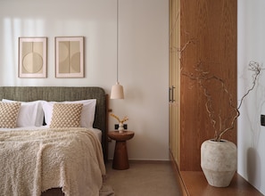 A bedroom with a bed, a bedside table with a vase, and a wooden wardrobe. - Eliterra Villa I, Timeless Serenity & Heated Pool (VPW4+V62 Elation, Greece)