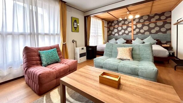 Ein modernes Wohnzimmer mit einer Couch, einem Couchtisch und einem Bett mit gepunktetem Kopfteil.