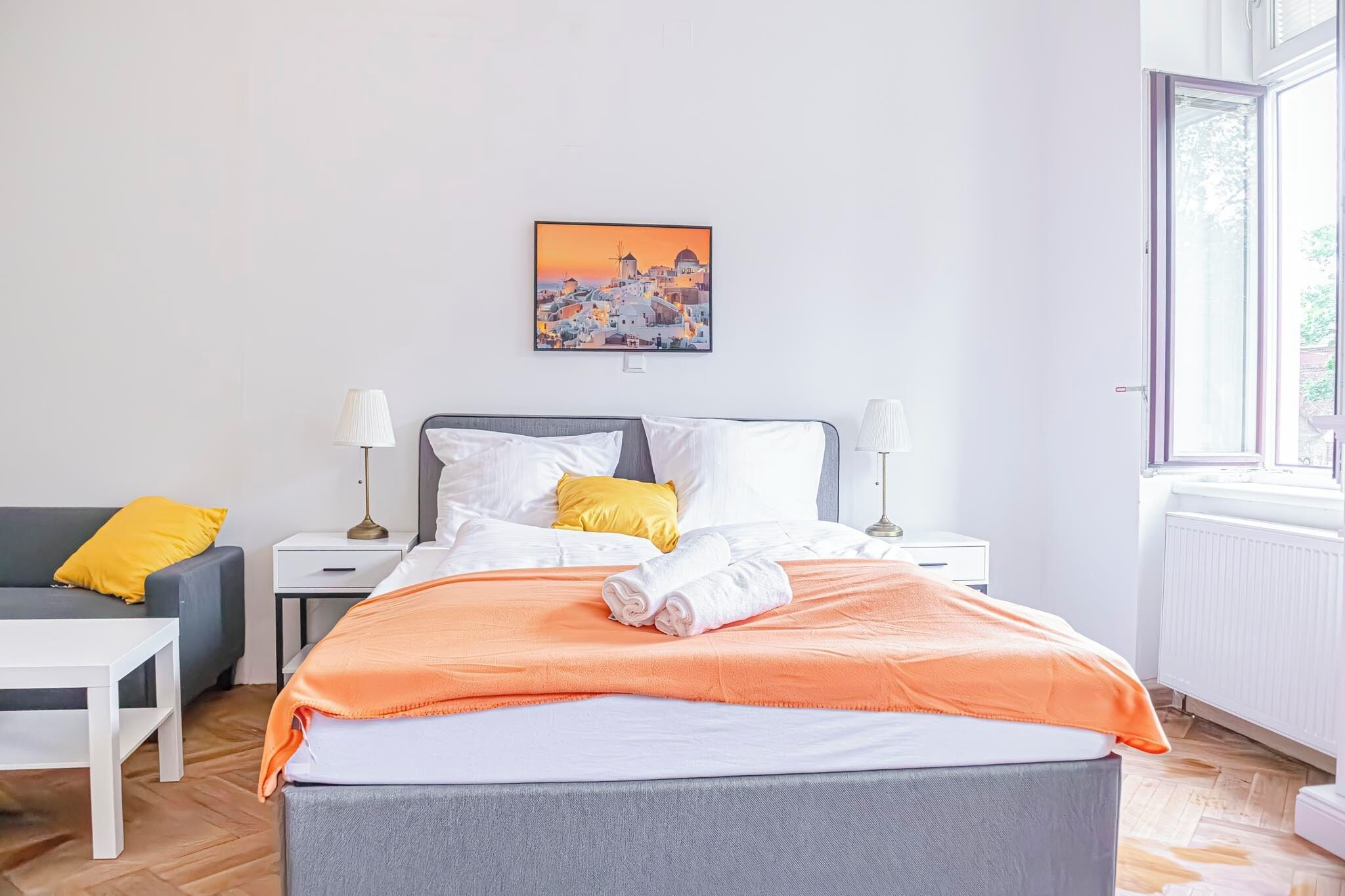 Een hotelkamer met een bed, twee nachtkastjes, een stoel en een raam.
