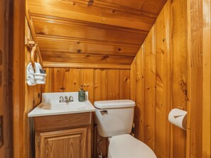 A compact wooden bathroom with a sink, toilet, and towel hanging on the wall. - Mountain Retreat -Hot Tub -Fire Pit -Stevens Pass -River Access -Pet Friendly (Index)