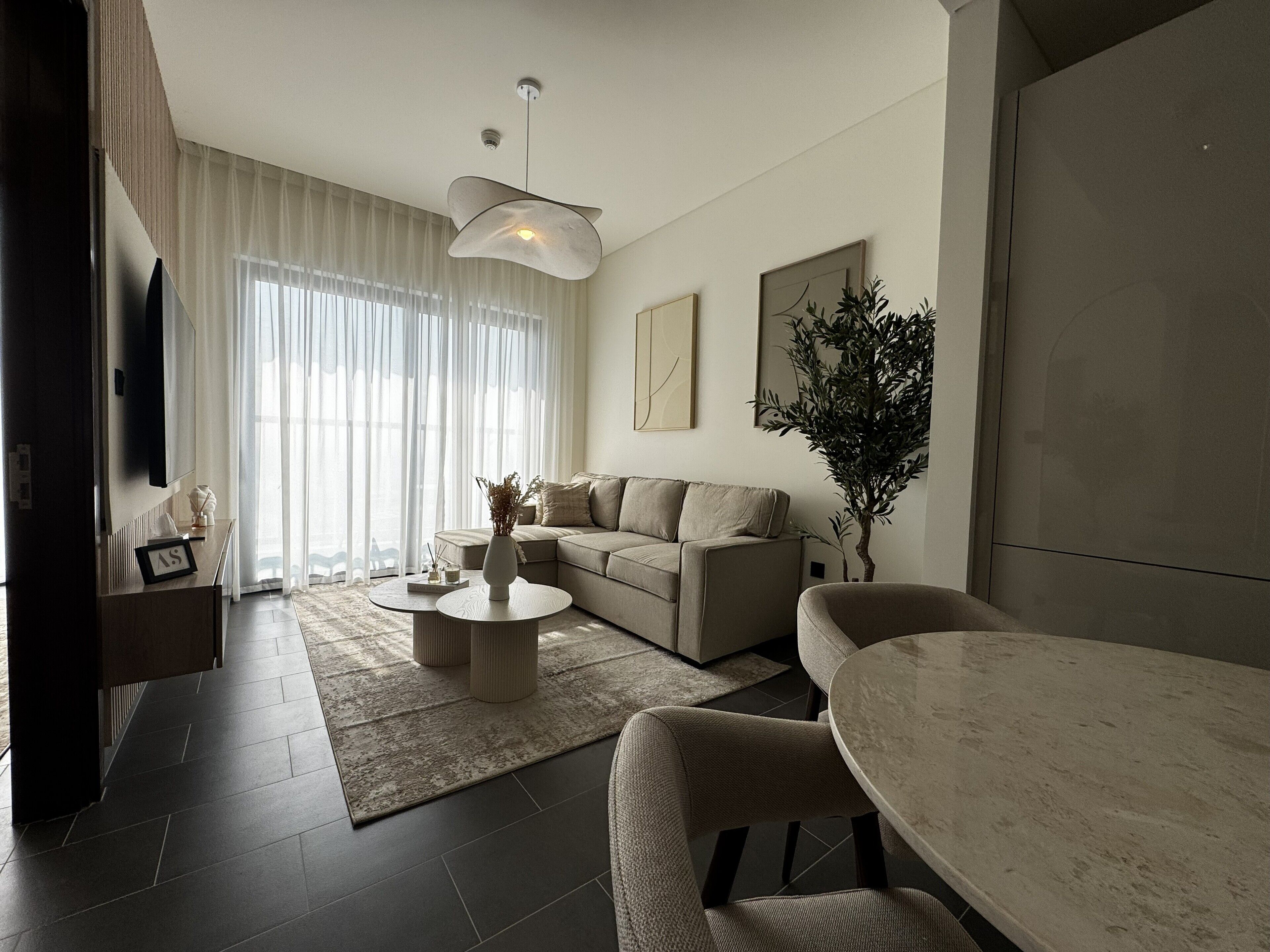 Ein modernes Wohnzimmer mit Sofa, Couchtisch und Essbereich.