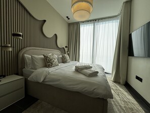 Apartemen Deluks, balkon, pemandangan halaman | Seprai premium, busa memori, brankas, dan tirai kedap cahaya