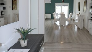 Een moderne keuken met een donker aanrecht, een potplant en een wit kastje.