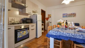 Cuina amb fogó, microones, forn i nevera. Hi ha un menjador amb estovell blau i espelmes.