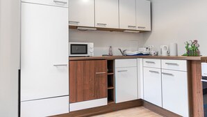 A modern kitchen with white cabinets, a microwave, and a coffee maker. - Cute 2BR Apt Near AKH Hospital Central (Vienna)