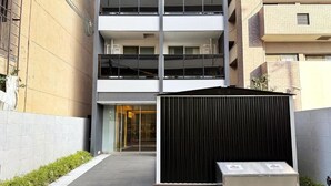Un bâtiment moderne à plusieurs étages, doté d’un espace extérieur couvert et d’un petit kiosque.