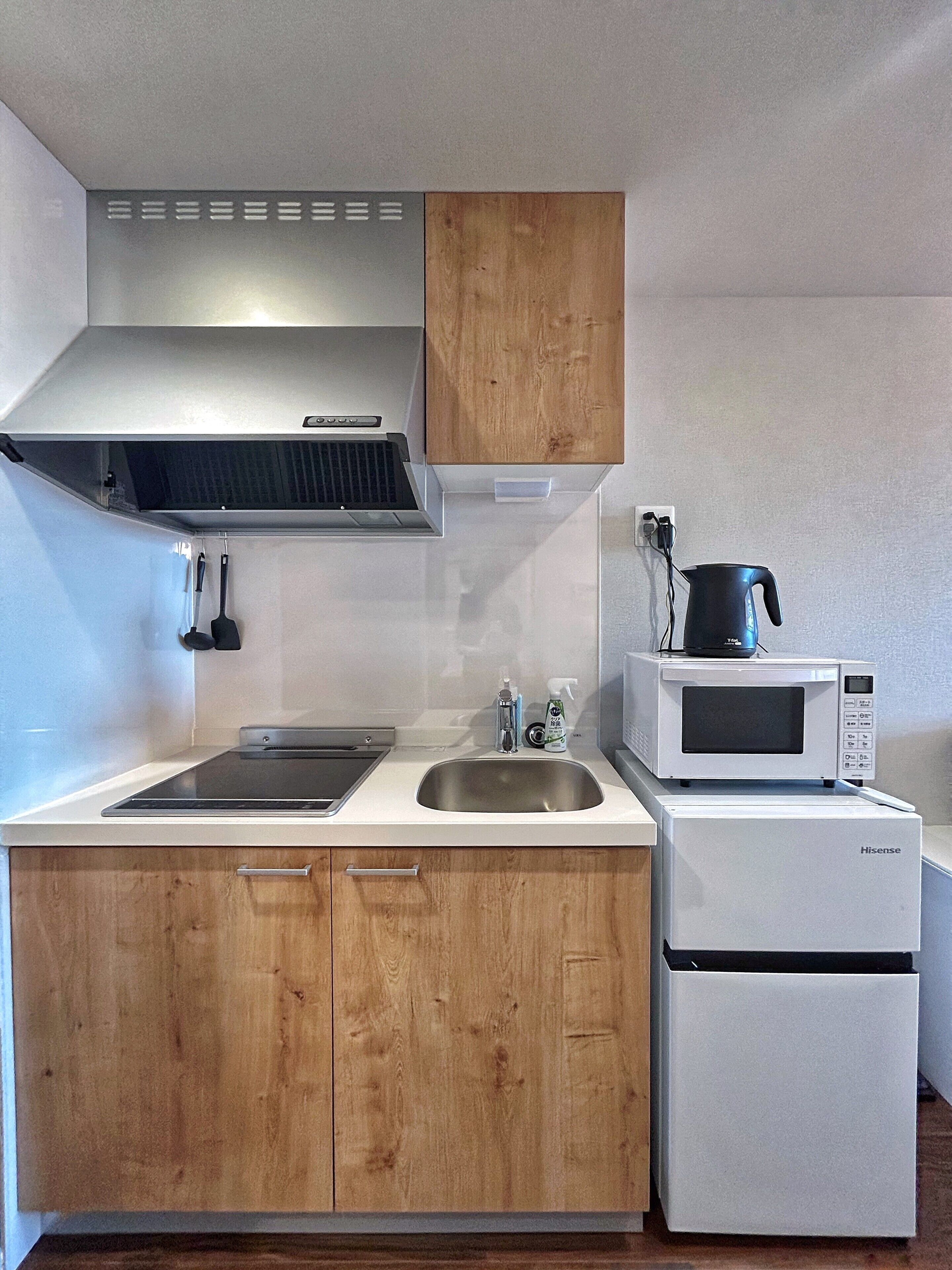 Quarto duplo conforto, sacada, vista para a cidade | Cozinha privada | Geladeira, micro-ondas, cooktop, talheres/pratos/utensílios de cozinha