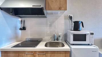 Quarto duplo conforto, sacada, vista para a cidade | Cozinha privada | Geladeira, micro-ondas, cooktop, talheres/pratos/utensílios de cozinha