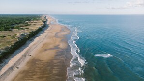 An aerial view of a beach with a long stretch of sand and a clear blue ocean. - South-facing Euronat studio with pool area, shops, restaurants, entertainment... (Grayan-et-l'Hôpital)