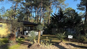 A residential property with a house, a patio, and a garden with various plants and trees. - South-facing Euronat studio with pool area, shops, restaurants, entertainment... (Grayan-et-l'Hôpital)