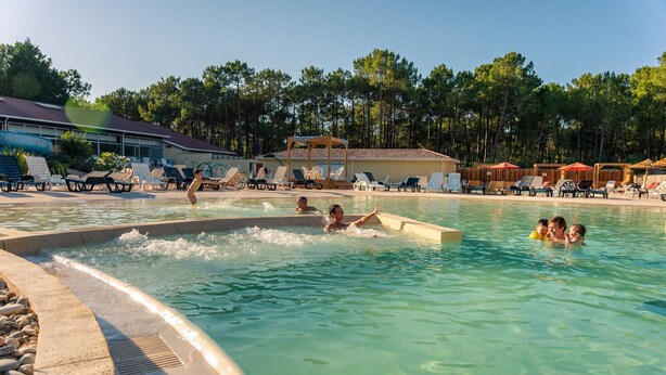 A swimming pool with people in the water, surrounded by lounge chairs and umbrellas. - South-facing Euronat studio with pool area, shops, restaurants, entertainment... (Grayan-et-l'Hôpital)