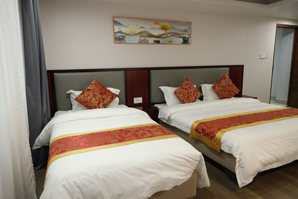 A hotel room with two beds, each with white bedding and red and gold decorative pillows. A painting of a landscape hangs above the beds. - Jiang Su Hotel and Restaurant (Kathmandu)