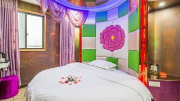 Een hotelkamer met een bed, een raam, een kaptafel en een kleurrijk ontwerp aan de muur.
