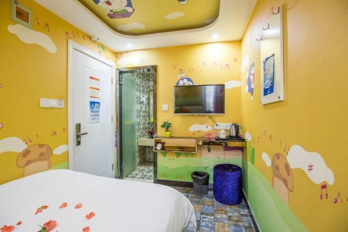 A room with a bed, a television, a sink, and a door.