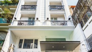 Ein Hotel mit moderner Fassade, einem zentralen Eingang mit Glastür und einer Treppe zum Eingang.