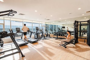 Ein Fitnessstudio mit Laufbändern, Crosstrainern und Gewichten.