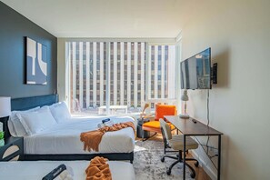 A hotel room with a bed, a desk, a chair, a TV, and a window with blinds. - Stylish ASU Stay Pool Gym Balcony Parking WD (Phoenix)