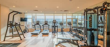A gym with treadmills, elliptical machines, and weightlifting equipment.