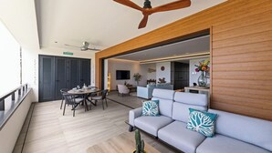 Ein modernes Wohnzimmer mit einer Couch, einem Esstisch und einem Deckenventilator.