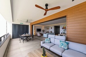 Una sala moderna con un sofá, una mesa de comedor y un ventilador de techo.