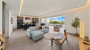 Ein moderner Wohnraum mit Sofa, Essbereich und einem Balkon mit Blick.