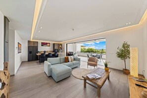 Un espacio habitable moderno con sofá, comedor y balcón con vistas.