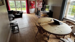Ein gemütliches Wohnzimmer mit einer Couch, einem Holzesstisch und einem Fernseher.