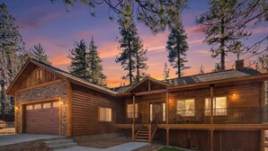 A two-story log cabin with a stone foundation, a covered front porch, and a staircase leading to the upper level. - Custom Log Style Cabin! Foosball! BBQ! Decks! Fenced Yard! (Big Bear Lake)