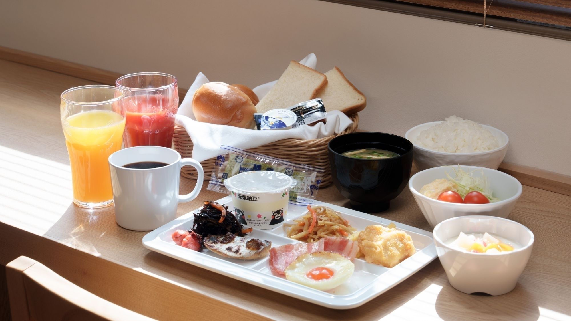 A breakfast tray with various foods and drinks, including toast, soup, rice, and a plate with eggs and meat.