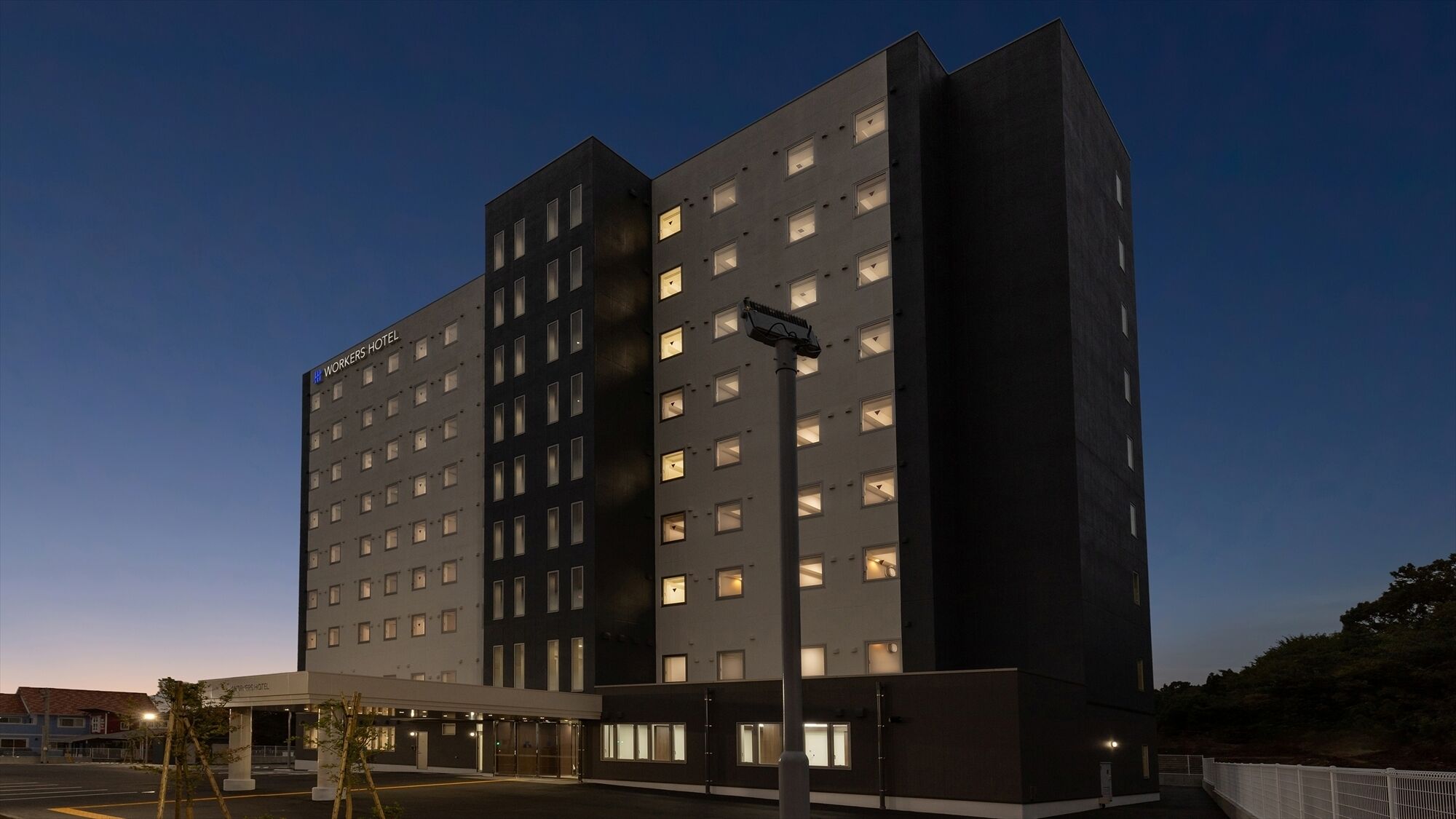 Un hotel de varios pisos con un diseño moderno, que cuenta con un techo plano y una fachada uniforme.