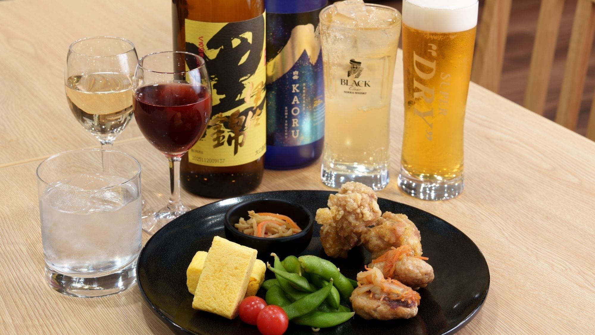 Una mesa con diversas bebidas, como cerveza y vino, y un plato de comida.