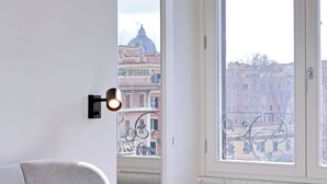Une pièce dotée d’une grande fenêtre, d’un radiateur et d’un luminaire fixé au mur.