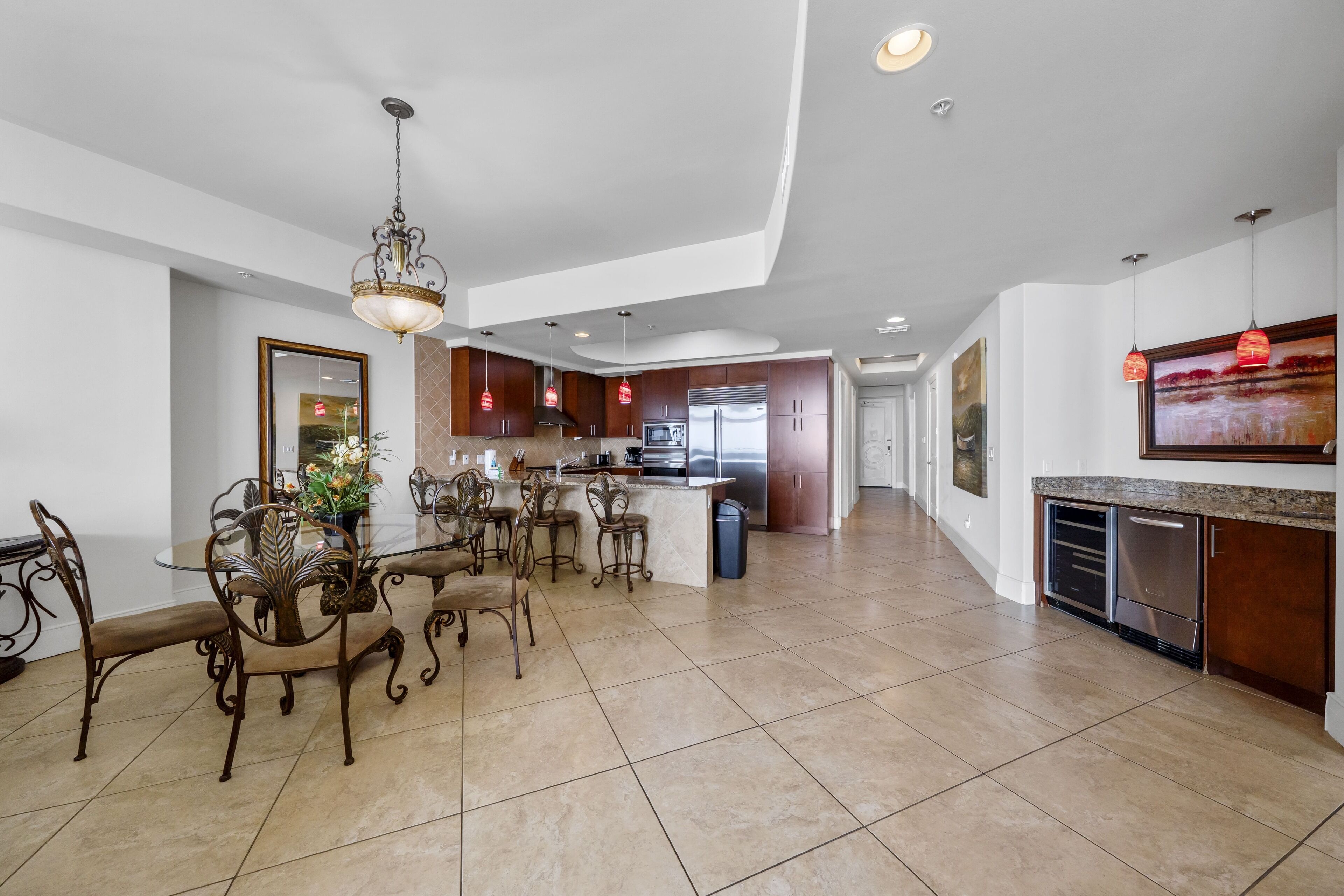 A spacious kitchen with modern appliances, a dining area with ornate chairs, and a large island.