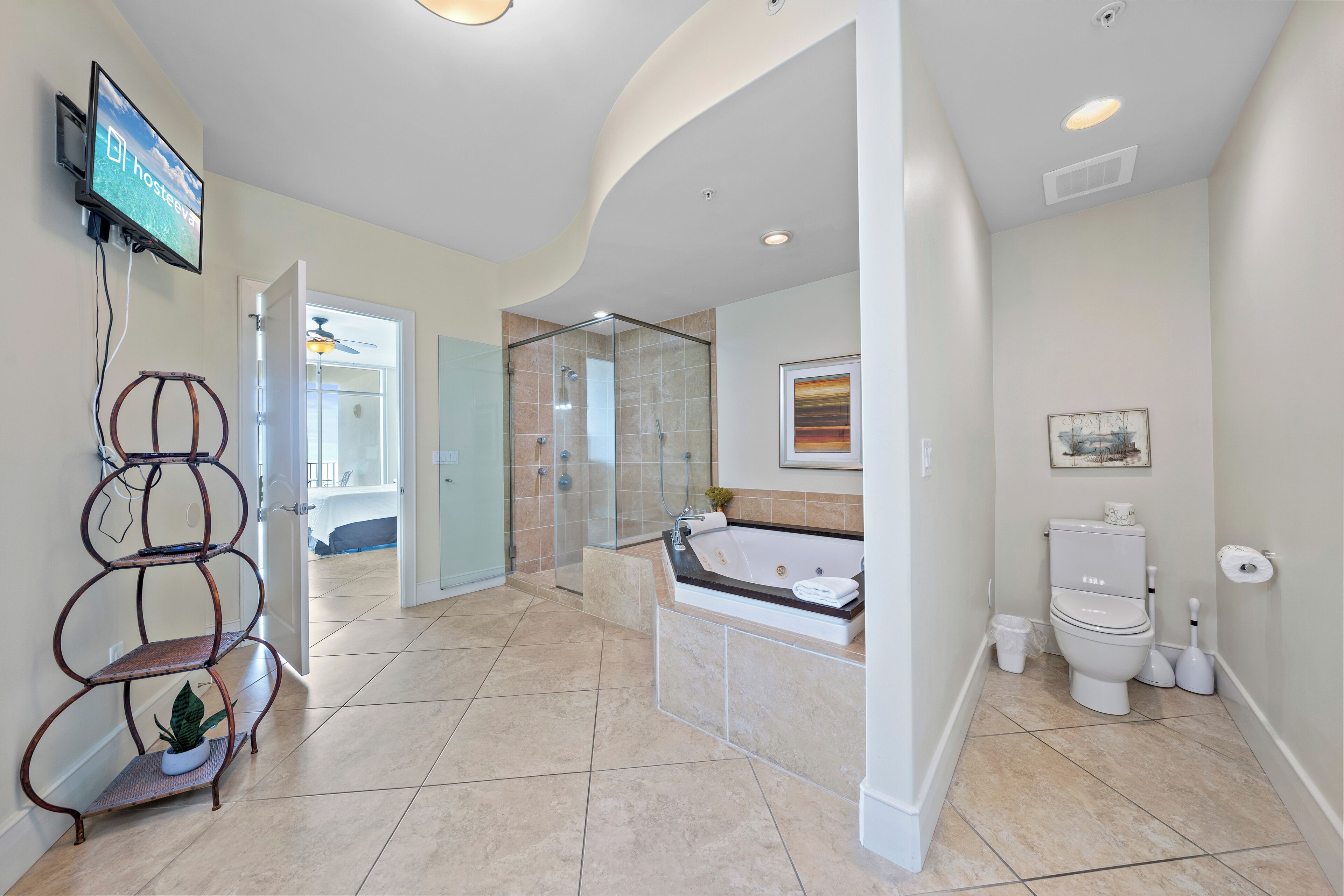 A modern bathroom with a glass-enclosed shower, a freestanding bathtub, and a toilet.