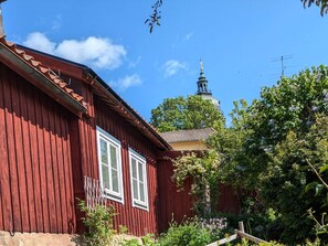 A red wooden building with white windows and a bell tower in the background. - 3 Person Holiday Home in Strangnas (Strängnäs)